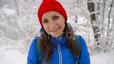 女人爬上一座白雪覆盖的山。 晴朗晴朗的霜冻天气